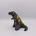 Matte finish ceramic sculpture of a T-Rex dinosaur, black with cream colored sgraffito line detailing and golden poppy flower designs on its back.