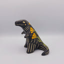 Matte finish ceramic sculpture of a T-Rex dinosaur, black with cream colored sgraffito line detailing and golden poppy flower designs on its back.