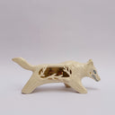 A cream colored ceramic wolf, with an opening in its body that holds gold charms, hanging from wire. Surrounded the opening are ceramic vine shapes.