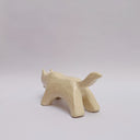 A cream colored ceramic wolf, with an opening in its body that holds gold charms, hanging from wire. Surrounded the opening are ceramic vine shapes.