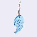 Blue acrylic charm of a small cartoon girl sitting down and smiling. It is attached to a ball chain.