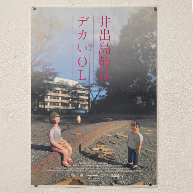 Faux movie poster for "Shizuka Idejima is a BIG OL" featuring posed vinyl figures in a scene - a woman sits on a curb and looks at a man.