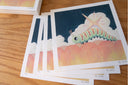 Stack of prints with a colorful caterpillar design on a wooden surface