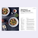 Recipe card for wontons in crispy chili oil with a photo of the dish on a dark surface.