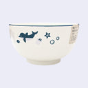 Off white bowl with purplish gray and blue colored illustrations of sea animals, such as dolphin, jellyfish and sea stars.