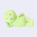Green plush toy resembling a simplistic character - akin to a baby, on a light gray background