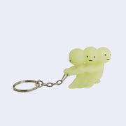 Group of 3 Smiskis, small green characters with round heads and vague expressions. They all pull one another, like tug of war and are attached to a keychain.