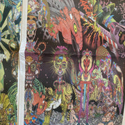 Close up photo of a page from Smoke Signal, a full bleed illustration with many colors and busy subject matter of aliens, people, skeletons and other psychedelic thematics and colorings.