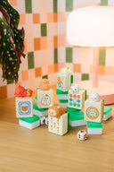 Set of colorful toy mahjong tiles with cartoon characters on a wooden surface.