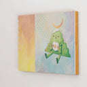 Painting of an anthropomorphized green mountain, sitting and taking a bite out of a rounded flower. Atop its head is a crescent moon and the background is light blue/yellow with an additional orange scalloped panel.