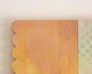 Painting of an anthropomorphized green mountain, sitting and taking a bite out of a rounded flower. Atop its head is a crescent moon and the background is light blue/yellow with an additional orange scalloped panel.