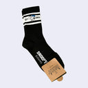 Black sock with white stripes and 'Snoopy' branding on a light gray background