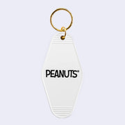 Back view of key tag, white diamond shaped with rounded edges and text that reads "Peanuts"