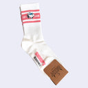 White sock with coral pink stripes and Snoopy logo on a white background