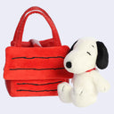 A red plush tote bag styled like Snoopy's house with black line details, shown next to a white and black Snoopy plush toy on a light gray background.