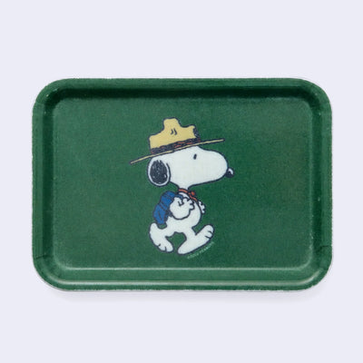 Forest green rectangular tray with rounded edges and a graphic of Snoopy dressed as a Beagle Scout, walking with a backpack.