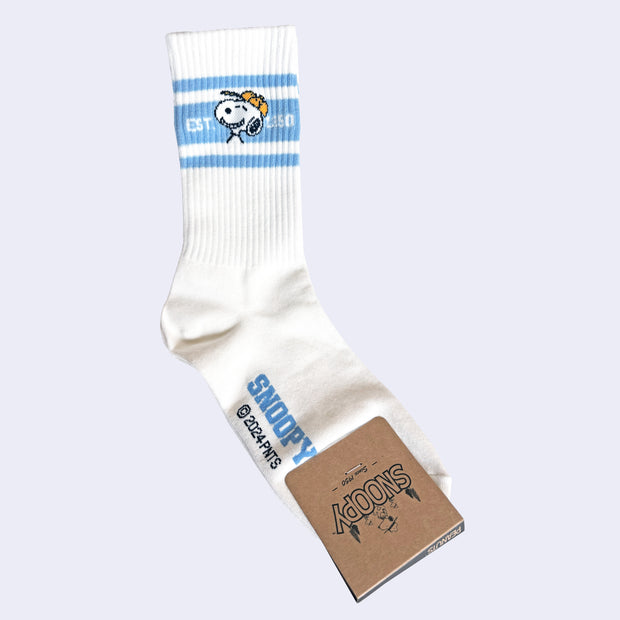 White socks with blue striping and an illustration of Snoopy's head, smiling wide while wearing a yellow baseball cap.