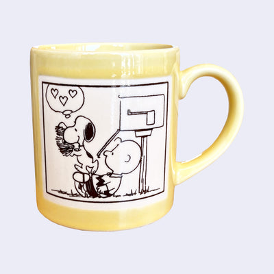 Yellow mug with a black and white illustration of Snoopy and Charlie Brown outside of their mailbox, Snoopy empties it by carrying away a pile of letters for him.