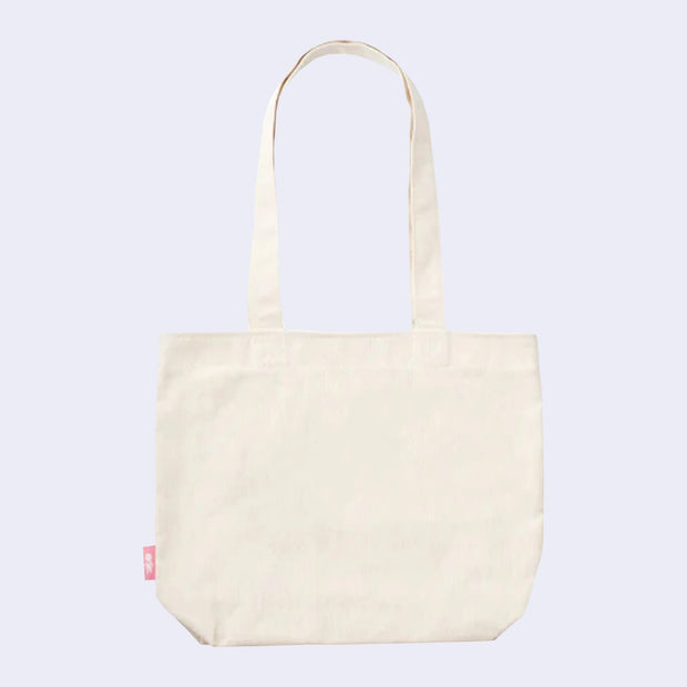 Back view of cream colored tote bag with a drop handle.