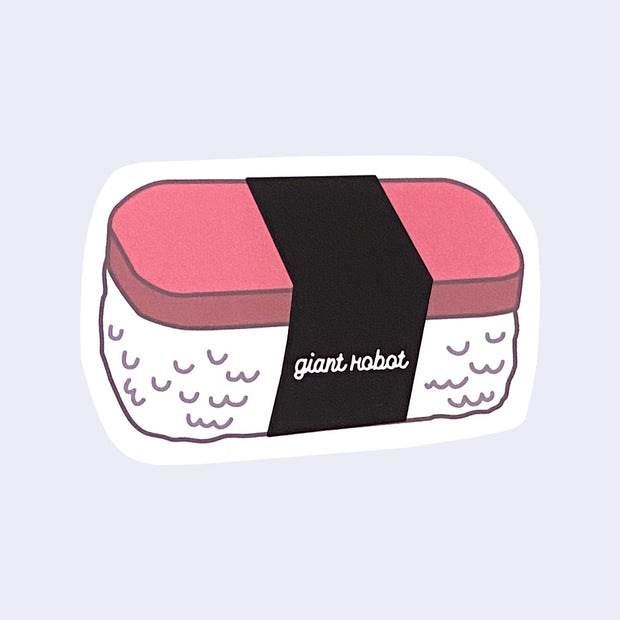 Die cut sticker of a spam musubi with "giant robot" written in cursive on the seaweed wrap.