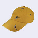 A mustard yellow baseball cap featuring embroidered birds on the front panels and brim, set against a light gray background.