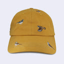 A mustard yellow baseball cap featuring embroidered birds of various species across the front panels and brim, set against a light gray background.