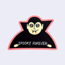 A die-cut sticker featuring a cartoon vampire with a pale yellow face, black cape, and red fangs, outlined in pink, with the text 'SPOOKY FOREVER' on a light gray background.