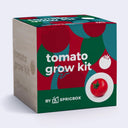 A cube-shaped product box for a tomato grow kit by Sprigbox, featuring a colorful red, green, and teal design with white text and a tomato illustration, set against a light gray background.