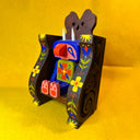 Colorful wooden figure of a cute, blue troll monster sitting in a wooden throne.