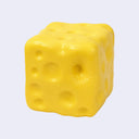 A yellow cube-shaped object with embossed holes, resembling a cheese cube, shown on a plain light background.