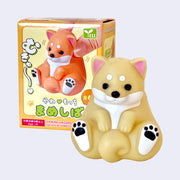 Toy figure of a dog with packaging on a light gray background