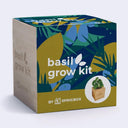 A square product box for a basil grow kit by Sprigbox, featuring a colorful tropical leaf pattern in blue, green, and mustard yellow on the top and front panels, with a light wood-grain side panel and white text.
