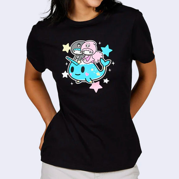 Black t-shirt featuring a graphic that takes up most of the width of the shirt. 2 small human characters, LittleTwinStar, ride atop of a smiling blue narwhal. Pink, blue and pastel yellow stars surround the image.