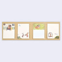 A set of four illustrated memo notes displayed side by side on a light brown cardstock backing against a pale gray background.