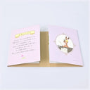 A small purple booklet with Japanese text and a rabbit illustration displayed open, showing a light pink front cover with Japanese text and a back view featuring an illustration of a rabbit holding a flower.
