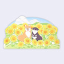 Flat die cut card of 2 shiba inu dogs sitting amongst sun flowers in front of a blue sky with fluffy white clouds.