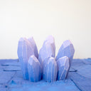 Cluster of wooden sculptures of purple crystals, outlined in white to give dimensionality. 