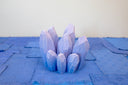 Cluster of wooden sculptures of purple crystals, outlined in white to give dimensionality. 
