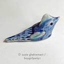 Ceramic sculpture of a blue bird.