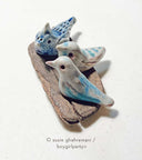3 ceramic birds on a piece of driftwood.