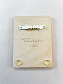 Back of wooden panel with a sawtooth hanger and raised dots.