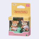 2 small deer dolls with flocked fur, dressed in little outfits for children. One pushes the other on a green train car. In their box.