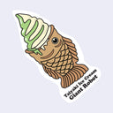 Die cut sticker of a taiyaki fish shaped waffle pastry with a swirl of matcha and vanilla soft serve in it, dripping slightly. Below is text that reads "taiyaki ice cream / Giant Robot"