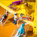 Collection of vintage action figures in packaging on a yellow surface