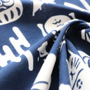Close-up of blue fabric with white design.