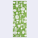 Green towel with white tea making utensil pattern on a light gray background