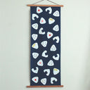 Rectangular tea towel, navy blue, with a repeating pattern of onigiri rice balls with different flavors.