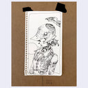 A black ink illustration on a white sheet of paper, taped to a brown kraft card. The drawing shows a stylized character in a bird-shaped helmet with mechanical details, and the card has handwritten text and tape marks below it.