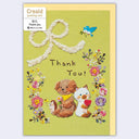 Greeting card with animals and flowers on a green background
