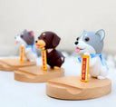 Three dog-shaped figurines on wooden stands with a white background